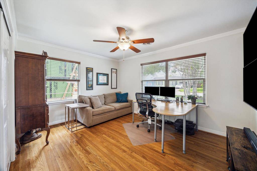 Flexible front room offers generous natural light and ample space for a dedicated office, reading nook, or additional lounge area.