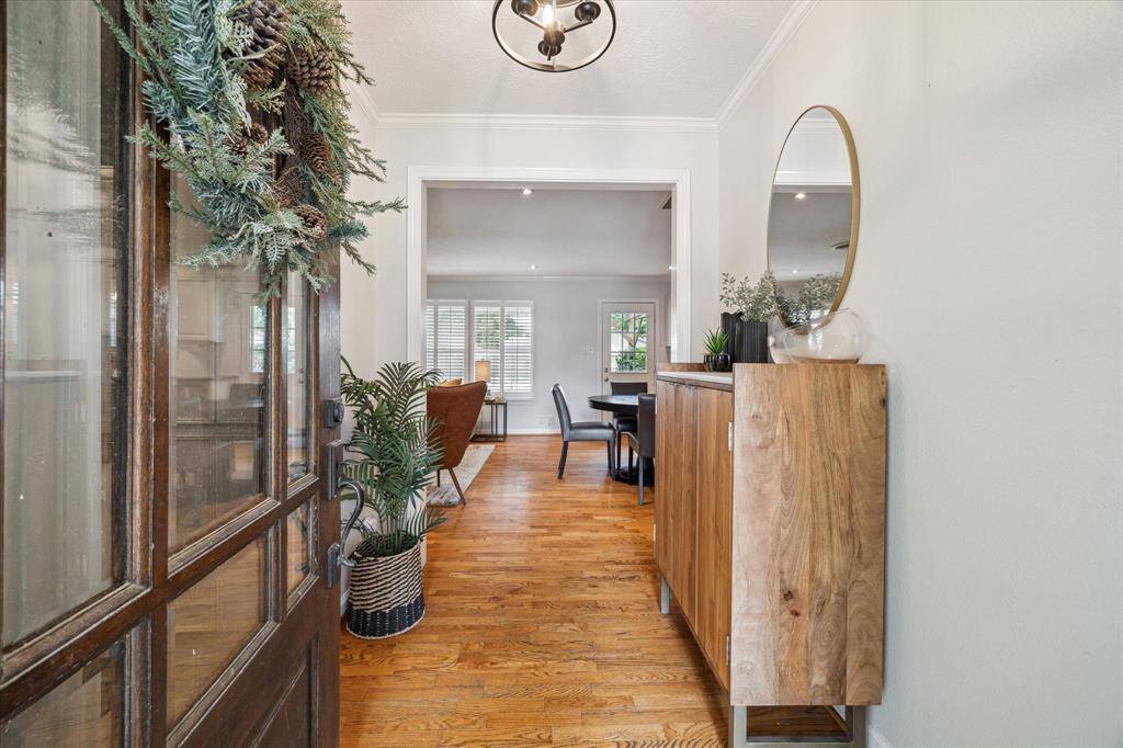 Warm wood tones and natural light welcome you into the entry, where hardwood floors flow seamlessly into the open-concept layout. Clean lines and curated accents set the stage for a home that feels both stylish and inviting.