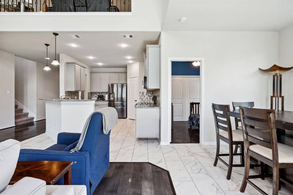 Living room features beautiful flooring, aceiling fan, high ceilings, and a wallof windows.