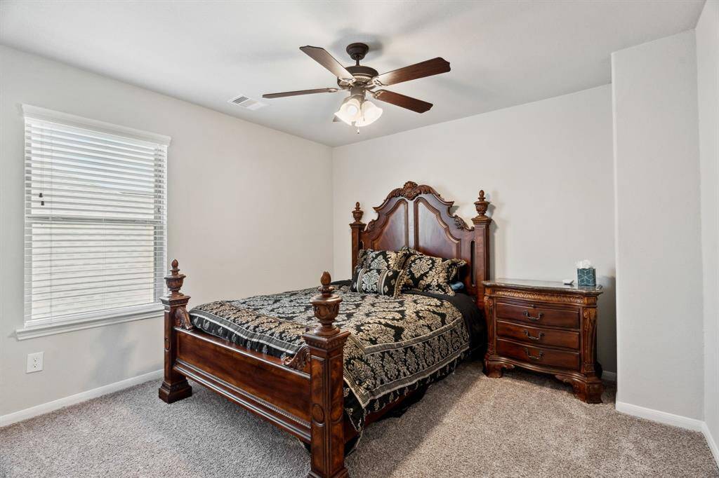 Secondary bedroom features awindow and plush carpet.
