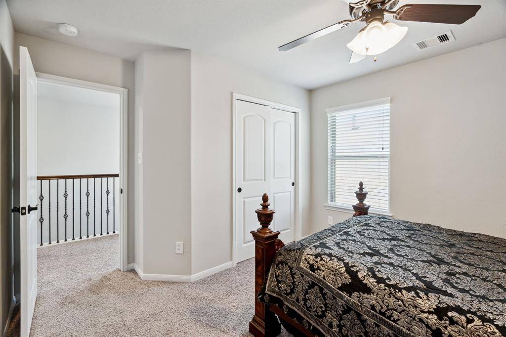 Secondary bedroom features awindow and plush carpet.