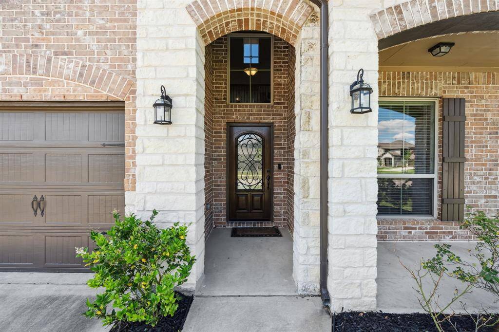 Approaching the front door you will see the brick and stone elevation, covered front porch, and landscaping.