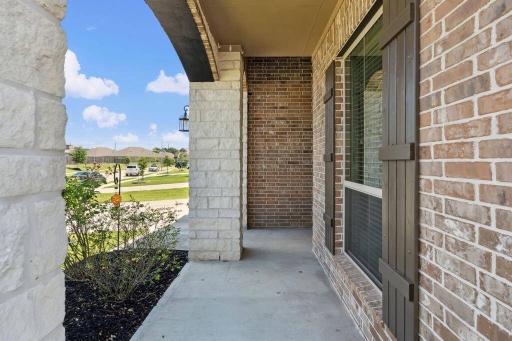 Approaching the front door you will see the brick and stone elevation, covered front porch, and landscaping.