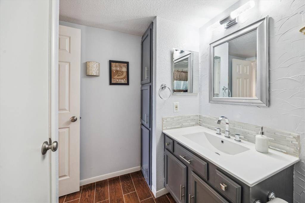 With ample storage in the vanity, a medicine cabinetry, and a floor-to-ceiling bank of cabinets, you’ll have plenty of space for all the necessities in this spotless bathroom.