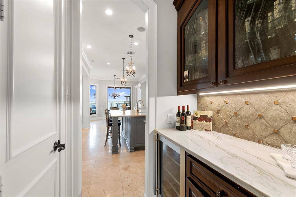 Butlers pantry with a wine fridge and glass front cabinets