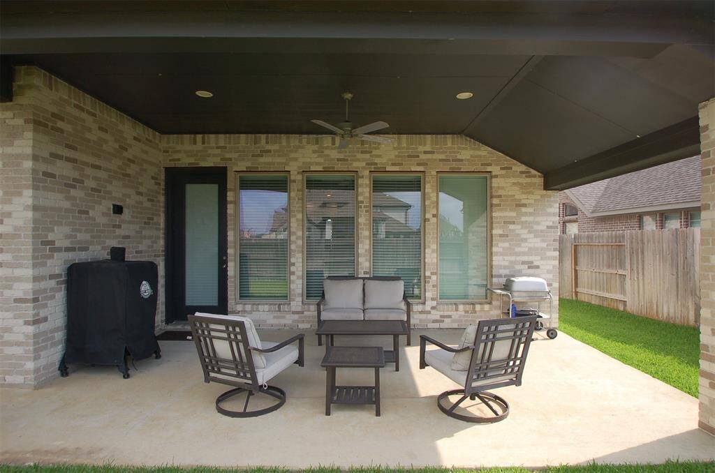 Covered back patio with ceiling fan.