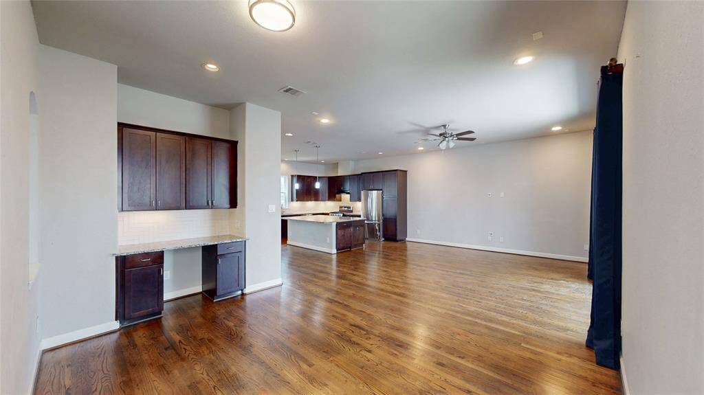 This spacious open-concept living area is perfect for comfortable living and entertaining with an extra bar complete with upper and lower cabinets.