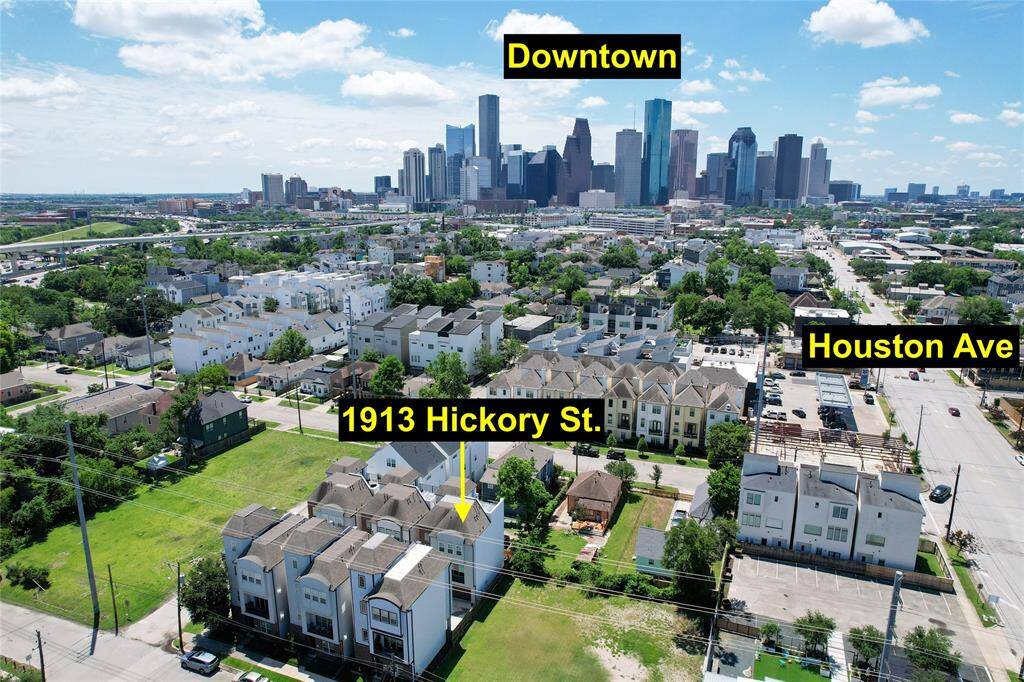 This aerial photo showcases a property at 1913 Hickory St. in a residential neighborhood, highlighting its proximity to downtown, offering convenient city access. The area features a mix of townhomes and green spaces, with Houston Ave nearby for easy commuting.