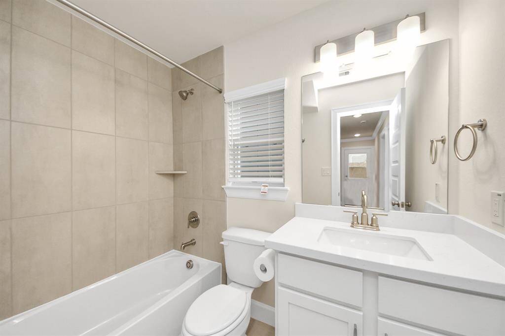 Stylish & Functional First-Level Bath - This full bathroom on the first floor blends sleek design with practical comfort. Featuring a deep soaking tub, modern fixtures, and a clean quartz-topped vanity, it’s the perfect complement to the two downstairs bedrooms. Neutral tile and soft lighting keep the vibe calm and inviting. Benefits: large tub with tiled surround; brushed nickel fixtures and bright lighting; and ideal for guests.Fresh, functional, and move-in ready.