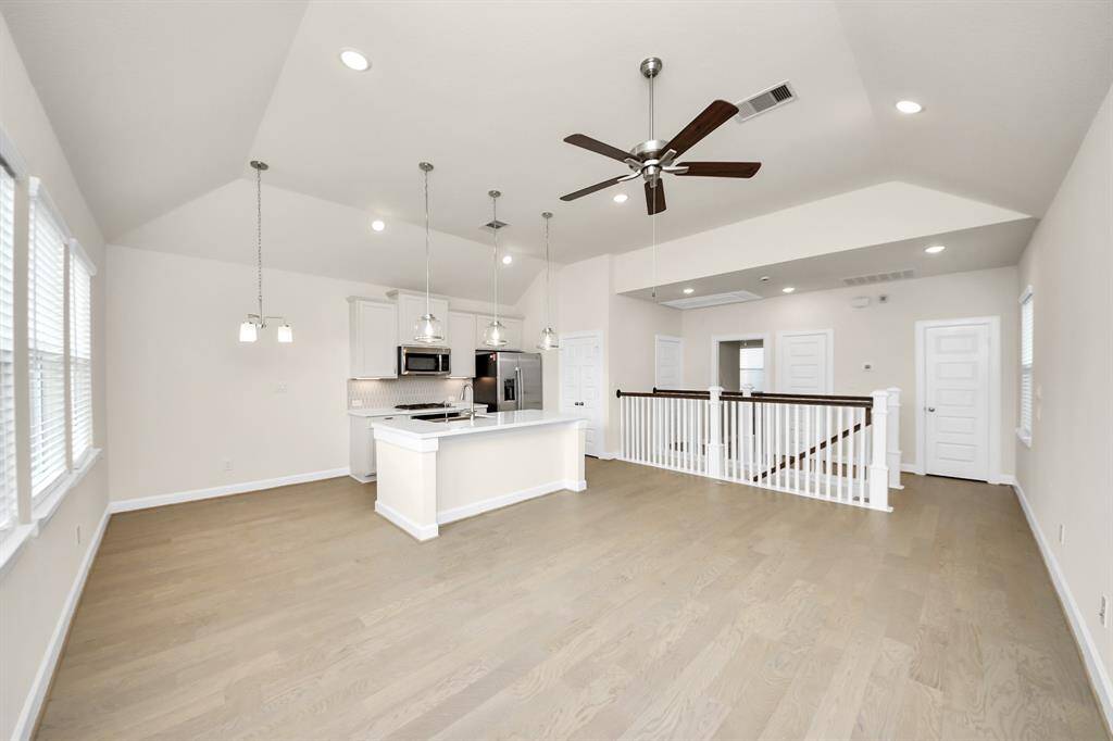 Bright. Airy. Open-Concept Living. -The heart of the home is where style meets comfort—featuring soaring vaulted ceilings, wide-plank hardwood floors, and tons of natural light. The open layout effortlessly connects the kitchen, dining, and living areas, making it perfect for everything from Sunday brunch to Netflix marathons. Benefits; modern pendant lighting & recessed lights; ceiling fan for comfort & airflow; and room to create your perfect hangout zone.