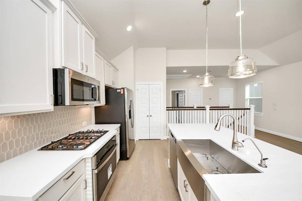 Modern Kitchen with Designer Touches -This kitchen was made to impress—and perform. From the sleek quartz countertops to the eye-catching backsplash and oversized island with deep basin sink, every detail is thoughtfully chosen. Cook like a pro with the gas range, entertain with ease, and enjoy a space that’s as stylish as it is functional. Benefits: Gas cooktop for precision cooking;stainless steel appliances including French-door fridgependant lighting adds a warm, modern glow and deep undermount sink.