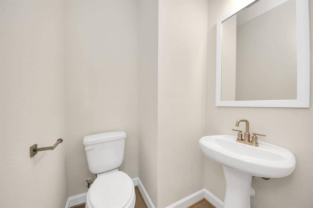 Stylish Powder Room off the Main Living Area - Conveniently located just off the main living space, this powder room combines simplicity and sophistication. With a sleek pedestal sink, brushed nickel fixtures, and neutral tones, it’s perfect for guests and everyday use alike. Benefits:Ideal for guests—no need to share the private baths; Clean, minimalist design; and quick access from kitchen, dining, and living areas. Form meets function in all the right ways.
