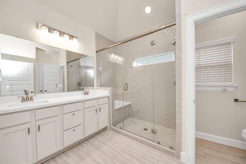 Spa-Inspired Primary Bath -Retreat to your private ensuite with a luxurious walk-in shower wrapped in herringbone tile and enclosed in sleek glass. Dual sinks, quartz countertops, and abundant storage bring both function and flair to your daily routine.