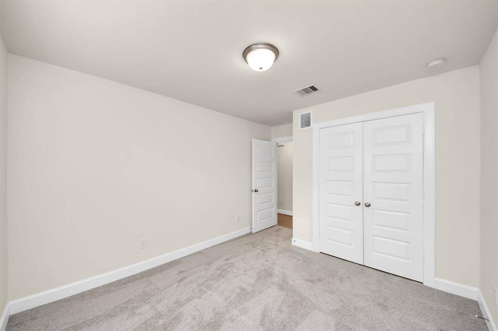 Bedroom Two – Comfort & Convenience - Located just steps from the full bath, this secondary bedroom on the first floor is ideal for guests, roommates, or your WFH office. Neutral tones and soft carpet make it a cozy retreat, while the double-door closet offers practical storage. Benefits: conveniently located next to the full bath; Peaceful, private space with flexible use and generous closet for clothes, gear, or extras. the room is quiet, comfortable, and totally yours.