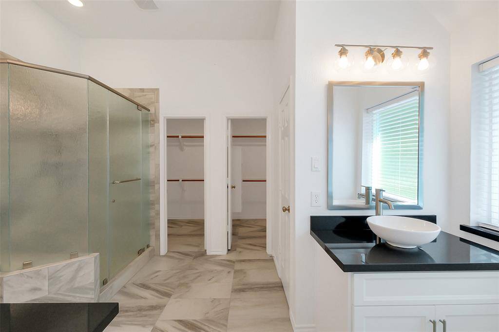Remodeled master bathroom with separate vanities and large shower.