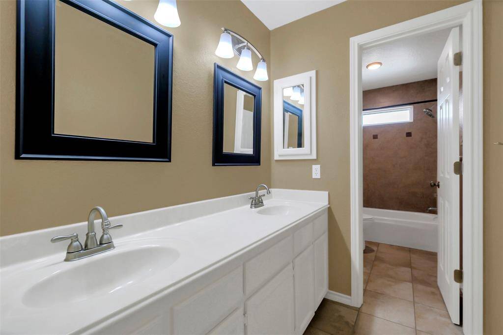 Secondary bathroom with double sinks.