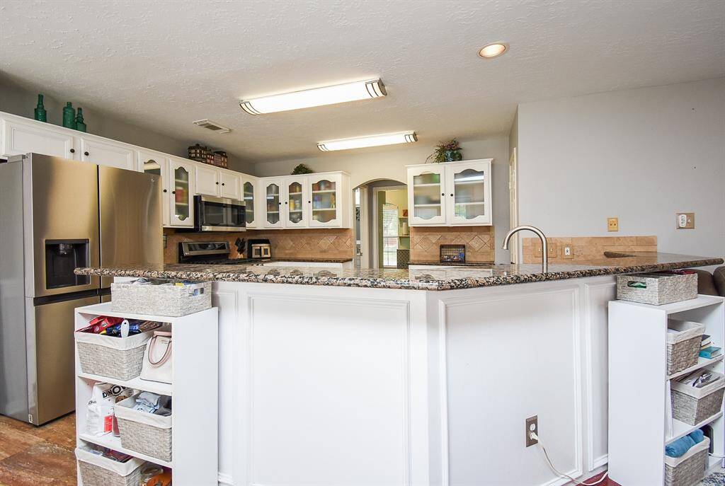 This angled kitchen counter not only offers storage space, but also stool space, for extra comfortable seating.