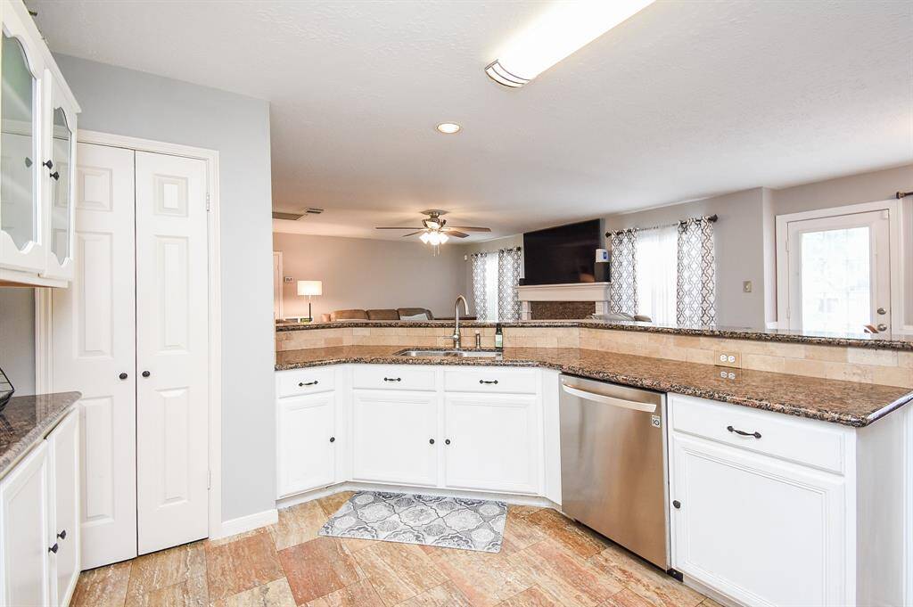 Creamy white cabinetry, up and down, is complemented by earth toned granite counter tops.