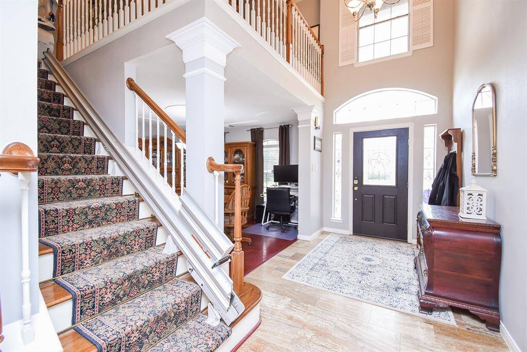 This view of the front entry, from the inside, is nothing less than magazine worthy; with pale/earth toned walls, tile flooring and a dramatic view to the upstairs railing, and the introduction of the carpeted staircase.
