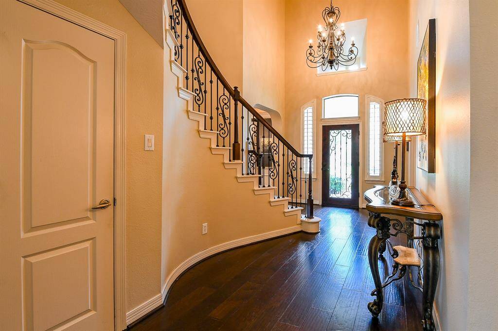 There is a large walk-in storage closet under the front staircase.  From this vantage point looking back toward the front door, you can see the beautiful wood floors, stunning foyer chandelier, and the grand appearance of this inviting front entry way.