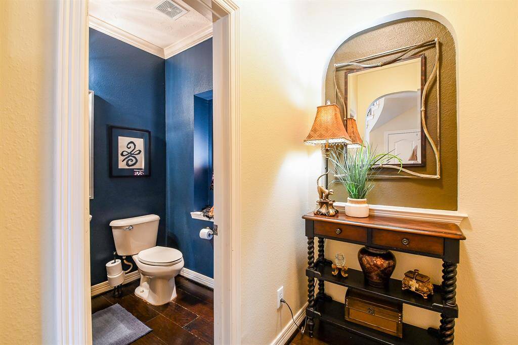 Located at the end of the front hallway just before the family room is this delightfully tucked away area which features a beautiful but secluded powder bath directly opposite the utility room (not shown).  The utility room features 2 laundry shoots and is lovely!