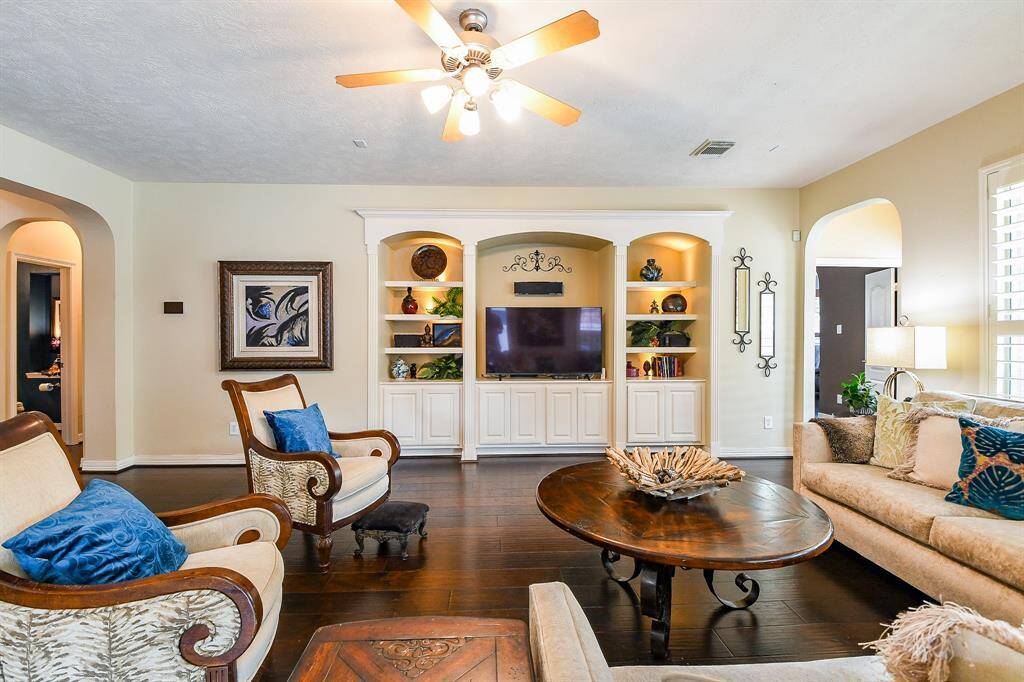 An alternate angle of the family room.  The built-ins along the far wall are perfect for your TV and other media, as well as collectibles or cherished family photos you proudly display.  The sound bar above the TV as well as certain other components to the surround-sound system will convey with the home.