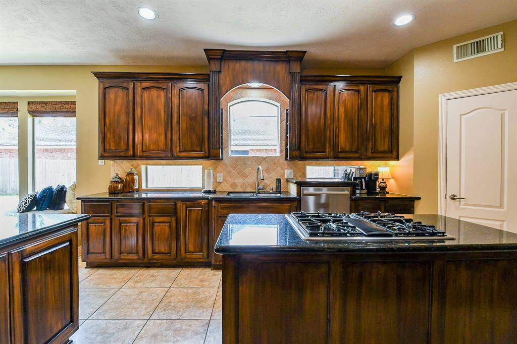 One last look at this amazing kitchen, from near the oven & microwave back toward the sink.  The beautiful windows allow so much natural light to pour through!  You're surely able to keep an eye on the kids playing in the driveway while doing the dishes or preparing a meal.