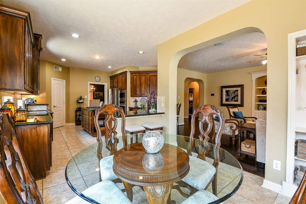 The breakfast area is adjacent to the kitchen and offers great views of the family room, outdoor covered patio, and driveway!  Glass table and chairs negotiable, per Seller.