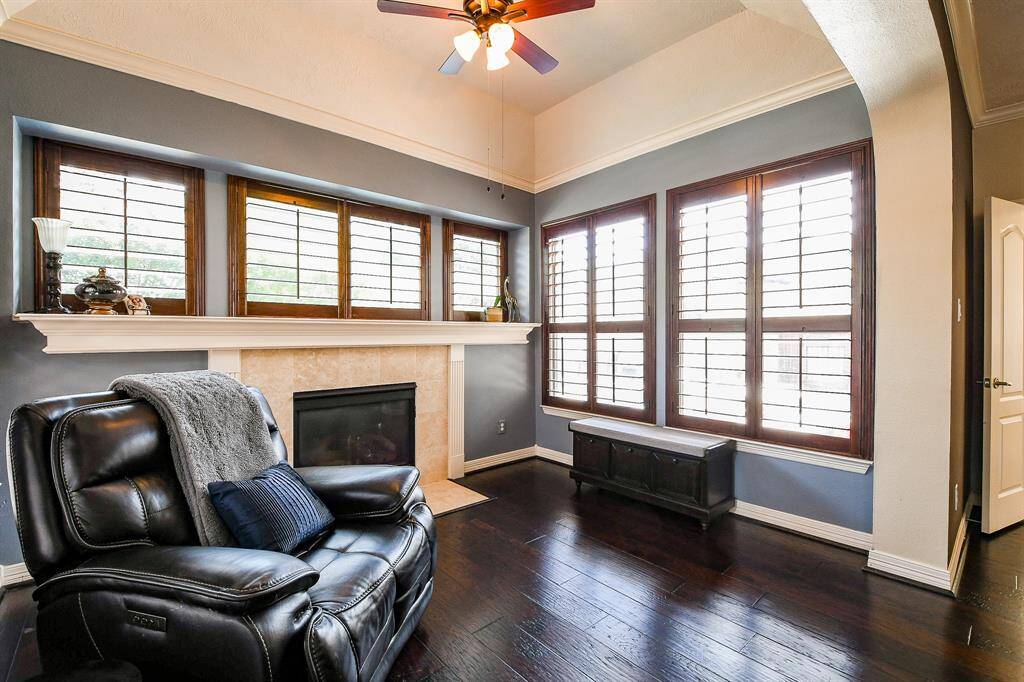 A closer look at the sitting room, which could be used for so many things!  Think reading or tv room, craft area, newborn nursery area, Peloton room, etc.  The gaslog fireplace has travertine surround and beautiful trim details.