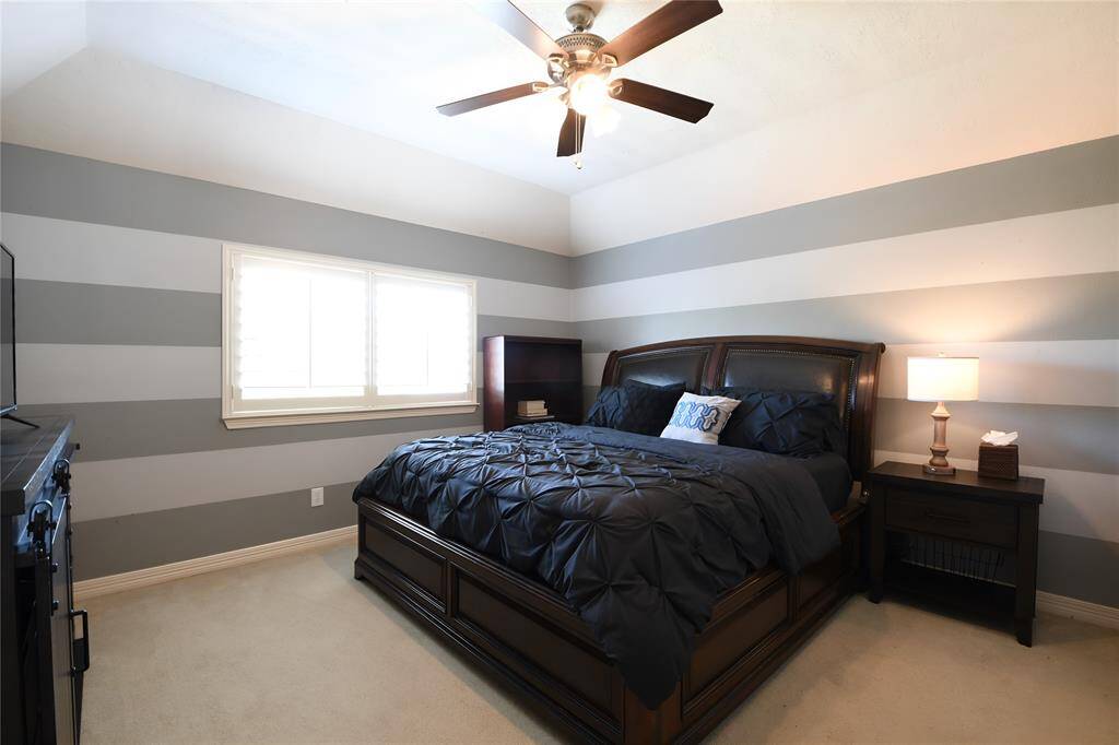 This ensuite bedroom is to the immediate right of the study nook, and features high ceilings, a ceiling fan, large closet, and of course, private bath.
