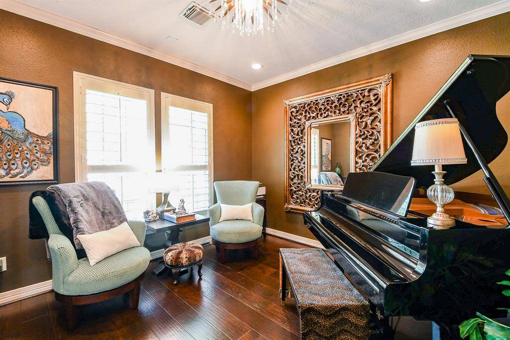 The formal living room, like most other rooms in this home, features real wood plantation shutters, updated lighting fixtures, and designer paint selections.