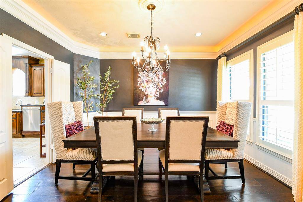 The formal dining room boasts plantation shutters & custom drapes, and mood setting rope lighting in addition to can lights & an elegant chandelier.