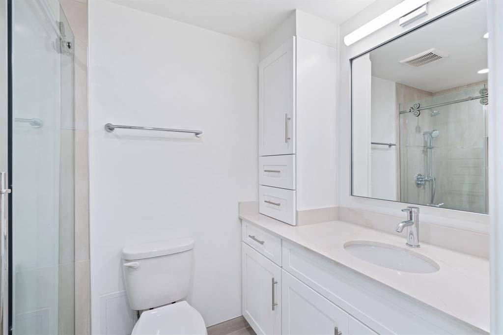 Guest bathroom with custom cabinetry, Quartz counters, designer fixtures and a seamless glass walk-in shower.