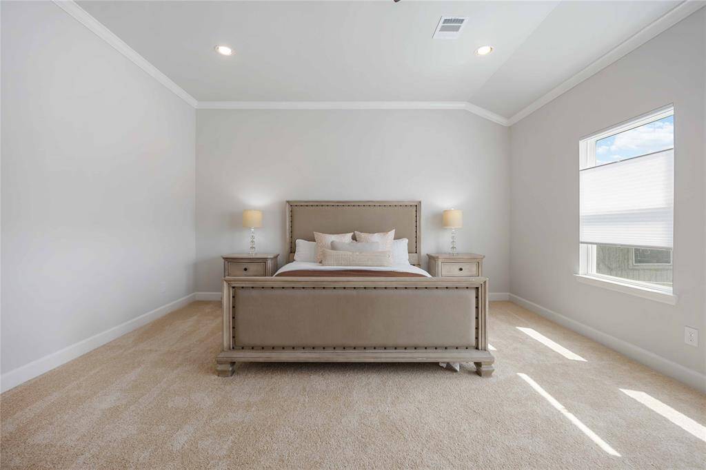 An expansive primary suite bathed in natural light, featuring high ceilings, plush carpeting, and custom Granger honeycomb shades for privacy and comfort.