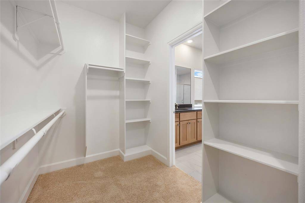 The bathroom's smart configuration provides access to one of two primary closets, a discreet water closet, and a separate linen closet, contributing to the home's abundant storage options.