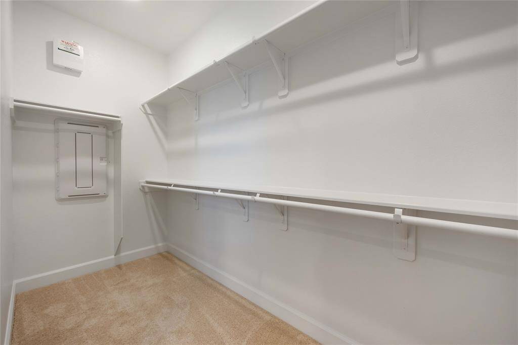 One of two generous walk-in closets with custom shelving provides ample storage.