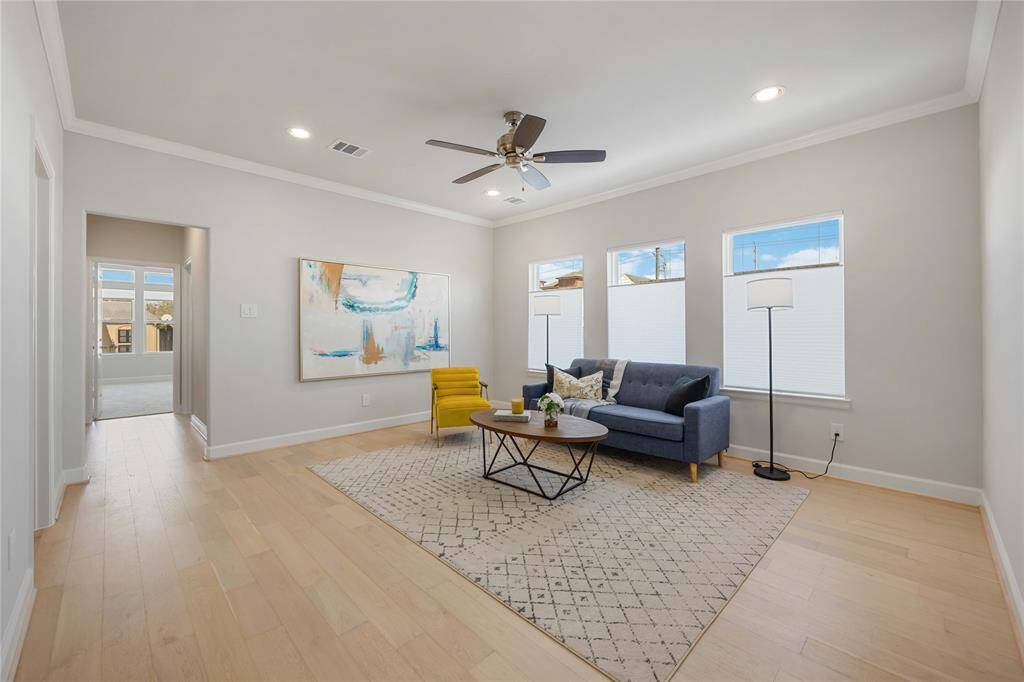 The second-story game room offers a bonus space bright for relaxation, positioned between the primary suite and a charming secondary bedroom, and illuminated by a wall of expansive windows.