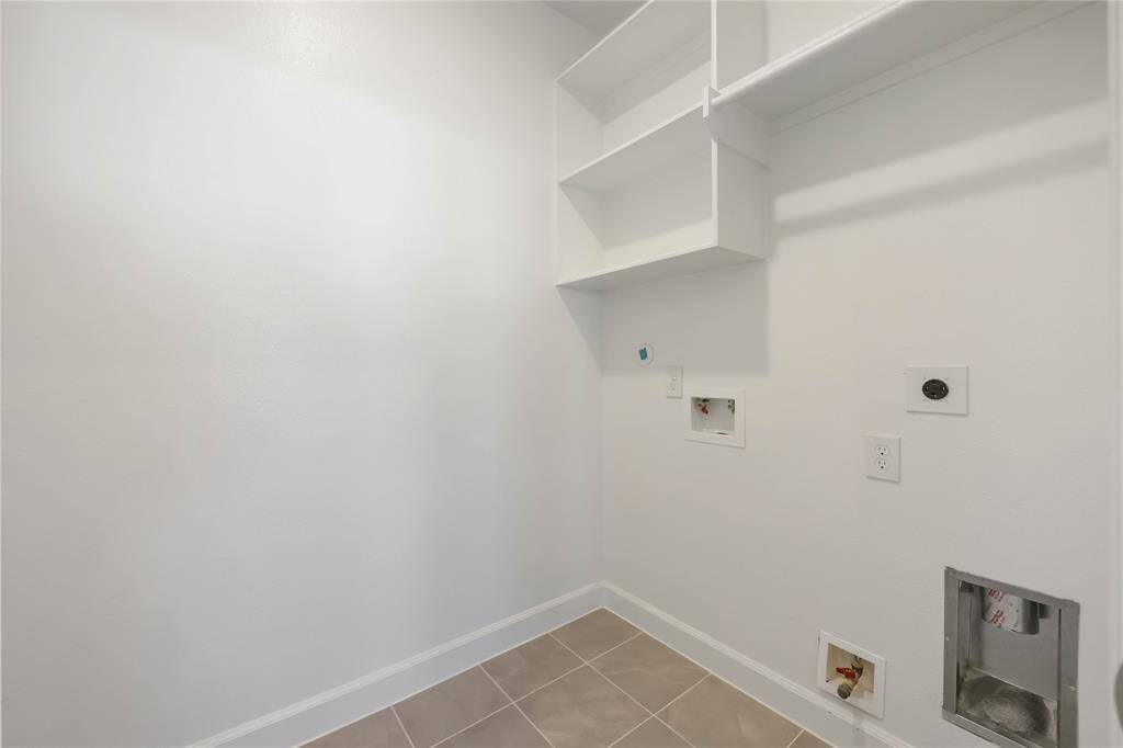 Located on the second floor, the laundry room offers convenience with space for side-by-side washer and dryer, complemented by hang and shelf space.