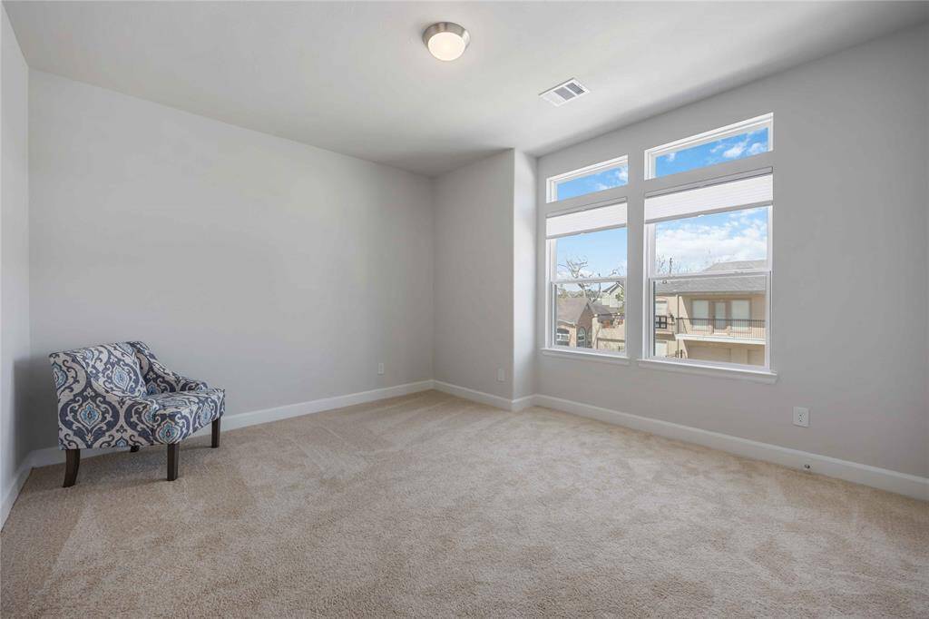The third spacious secondary bedroom with large windows and walk-in closet on the second floor.