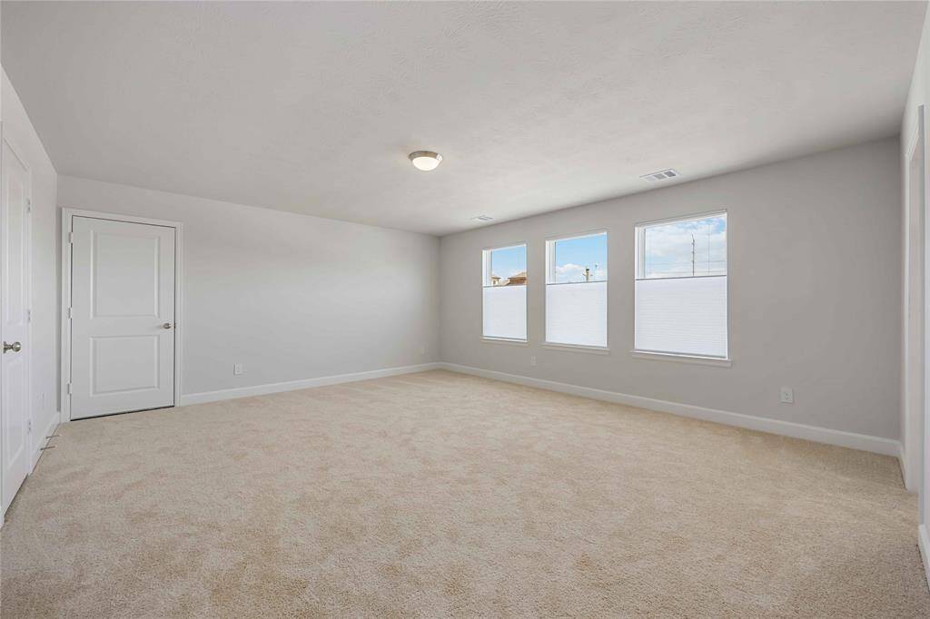 An oversized third-floor bedroom with abundant natural light, offering endless possibilities as a private guest suite, media room, or home gym.