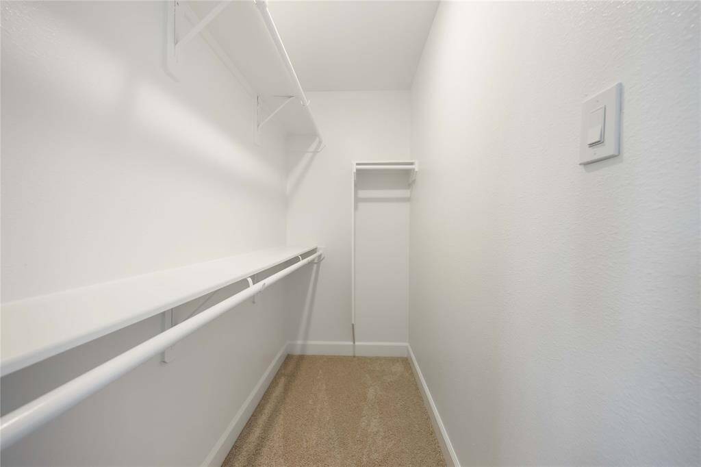 A generous walk-in closet with built-in shelving and ample hanging space, in this private third-floor suite.