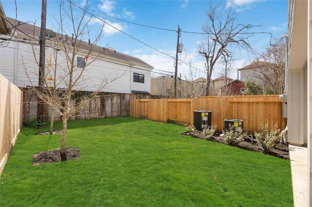 The lush, fully fenced backyard offers a secluded haven for entertaining, gardening, or simply unwinding beneath the open sky.