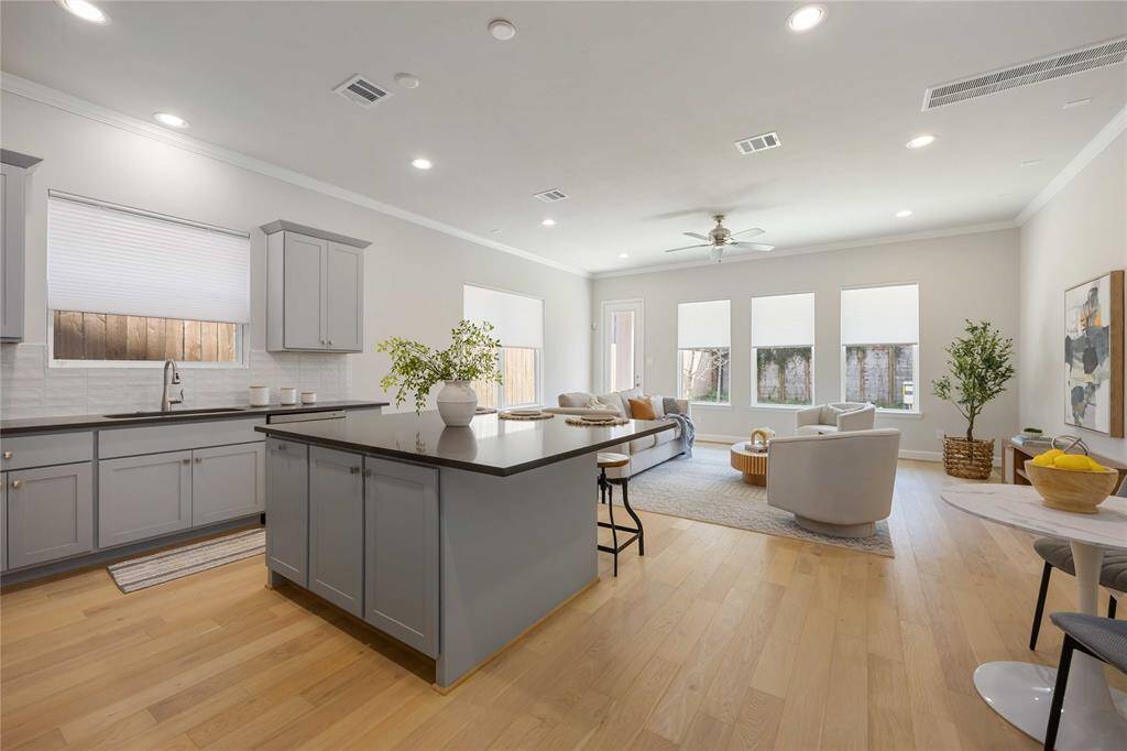The oversized island features adjustable shelves—ideal for storing cookbooks or everyday essentials—while offering a beautiful vantage point of the open-concept first-floor living space.
