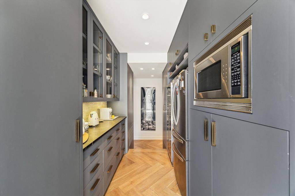 Seamlessly integrated dining space, furnished with a custom-built table and elegant banquette seating, effortlessly connected to the open-concept living area and kitchen for a refined, yet inviting ambiance.