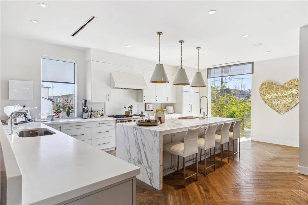 Standing in the chefs kitchen, you can always be engaged with your guests and family as you prepare snacks or meals for everyone. The current owner is using the space where the white table is for display. But it easily accomodates an additional dining room option.