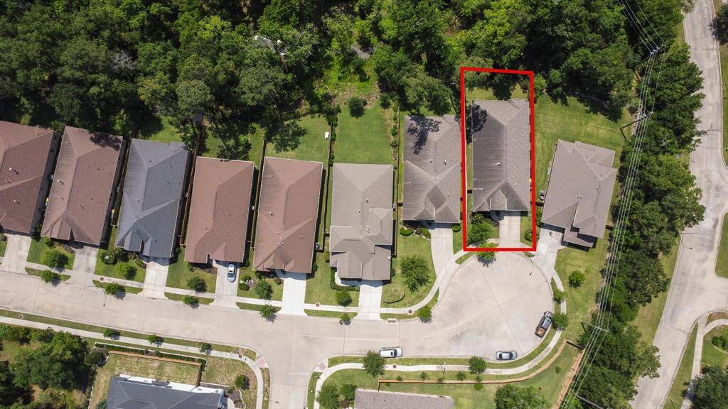 This aerial photo shows the private cul-de-sac, the subject property is highlighted with a red outline. It's surrounded by trees and neighboring homes with similar architecture, set in a well-maintained neighborhood.