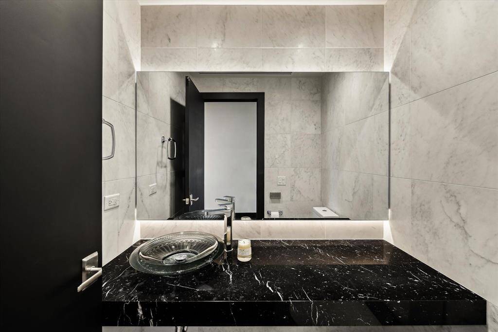 A Modernized half bath with the ambiance lit with uplighting.