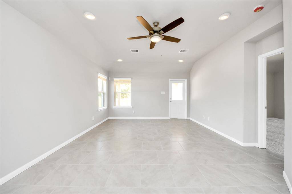 Gather the family and guests together in your lovely living room! Featuring soaring high ceilings, recessed lighting, ceiling fan, custom paint, gorgeous floors, and large windows that provide plenty of natural lighting throughout the day.