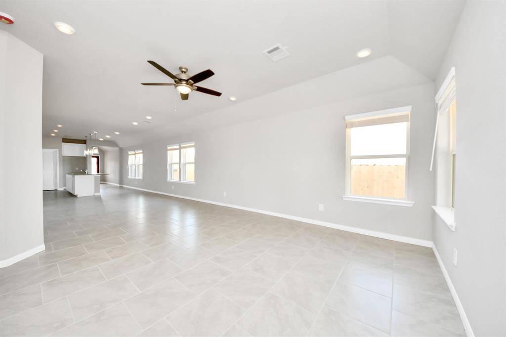 Gather the family and guests together in your lovely living room! Featuring soaring high ceilings, recessed lighting, ceiling fan, custom paint, gorgeous floors, and large windows that provide plenty of natural lighting throughout the day.