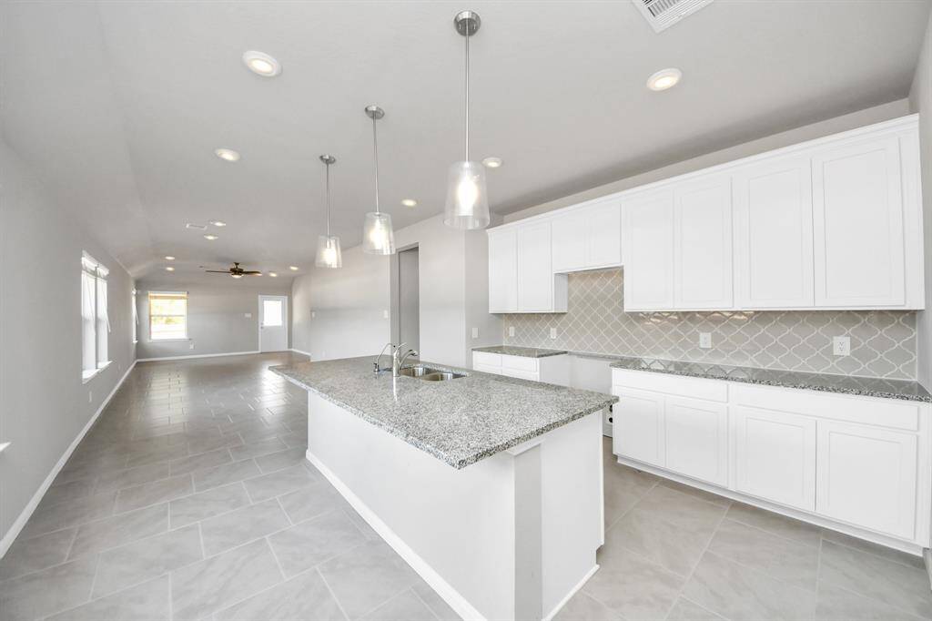 This kitchen is by far any chef’s dream! This spacious kitchen features high ceilings, light stained wood cabinets, granite countertop, SS appliances, modern tile backsplash, recessed lighting, extended counter space, granite kitchen island with double sink, and space for breakfast bar, and a walk-in pantry all overlooking your huge family room.